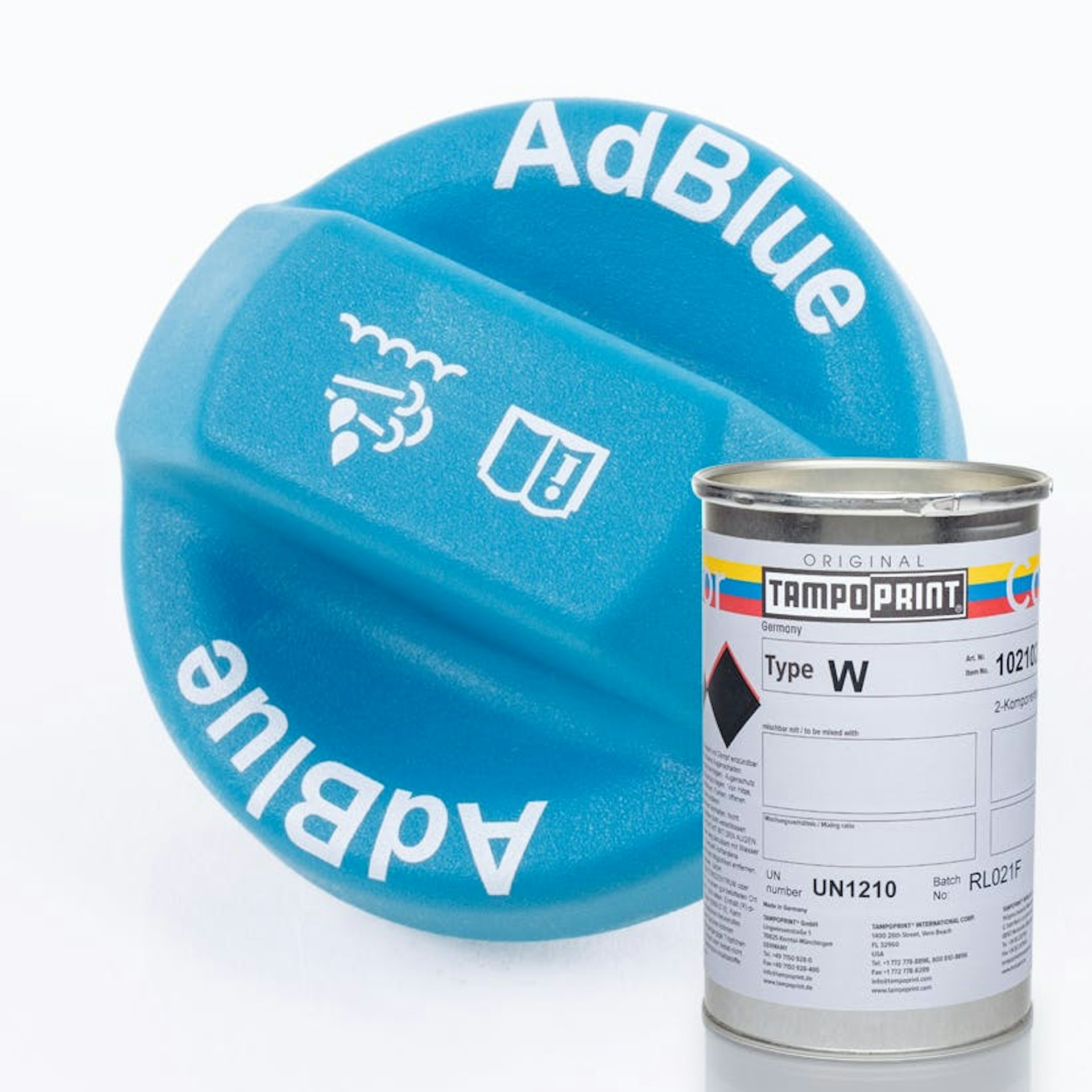 Eine Type W Tampondruckfarbdose mit blauem AdBlue Deckelschraubverschluss im Hintergrund.