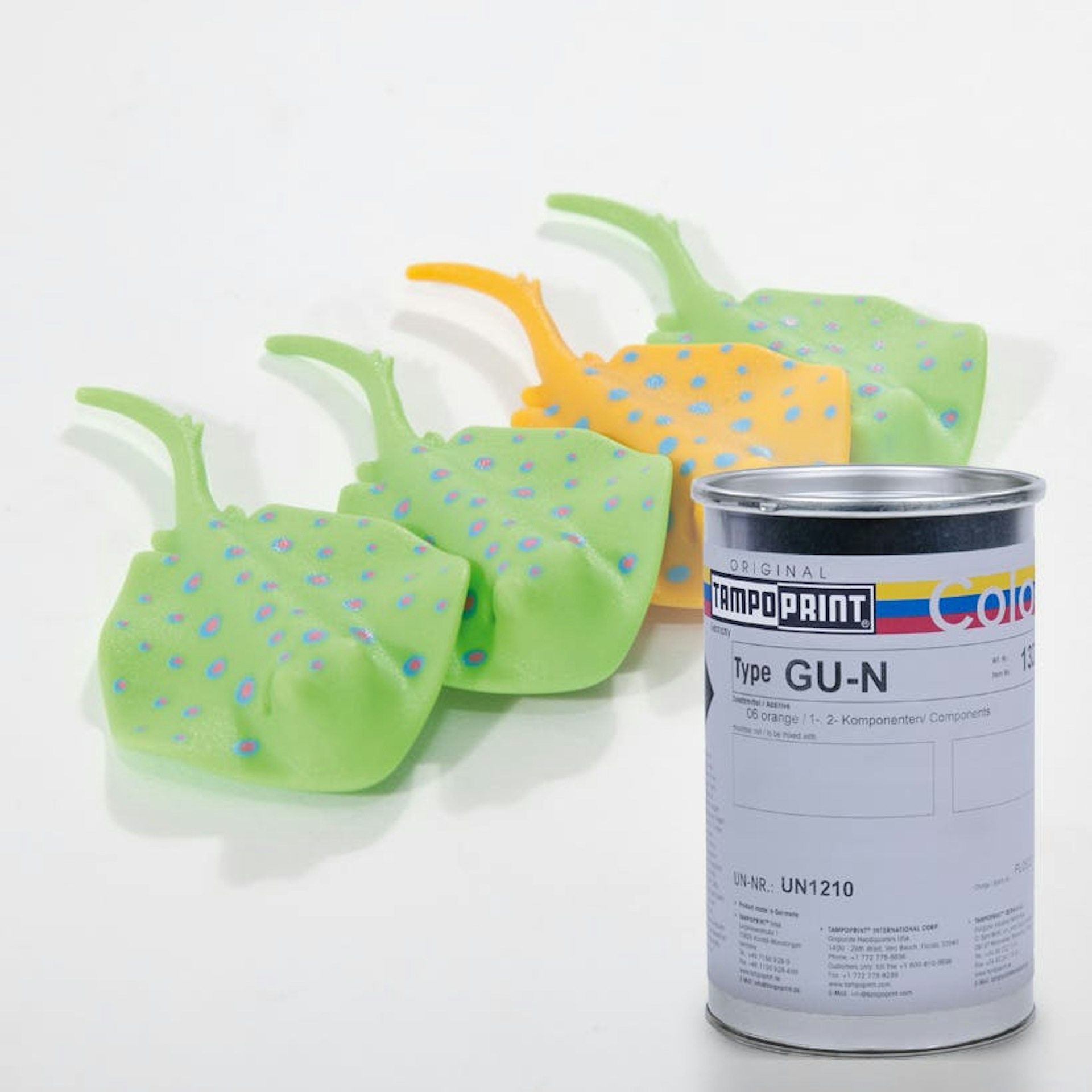 Eine Type GU-N Tampondruckfarbdose mit Kinderspielzeug aus Gummi im Hintergrund.